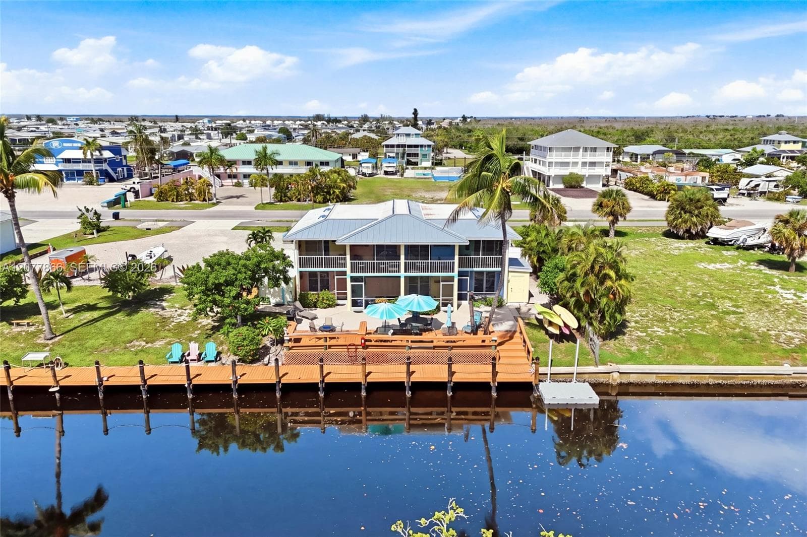 The expansive waterfront deck creates an inviting gathering space for guests to relax, entertain, enjoy beautiful sunsets, and watch for dolphins along the canal.