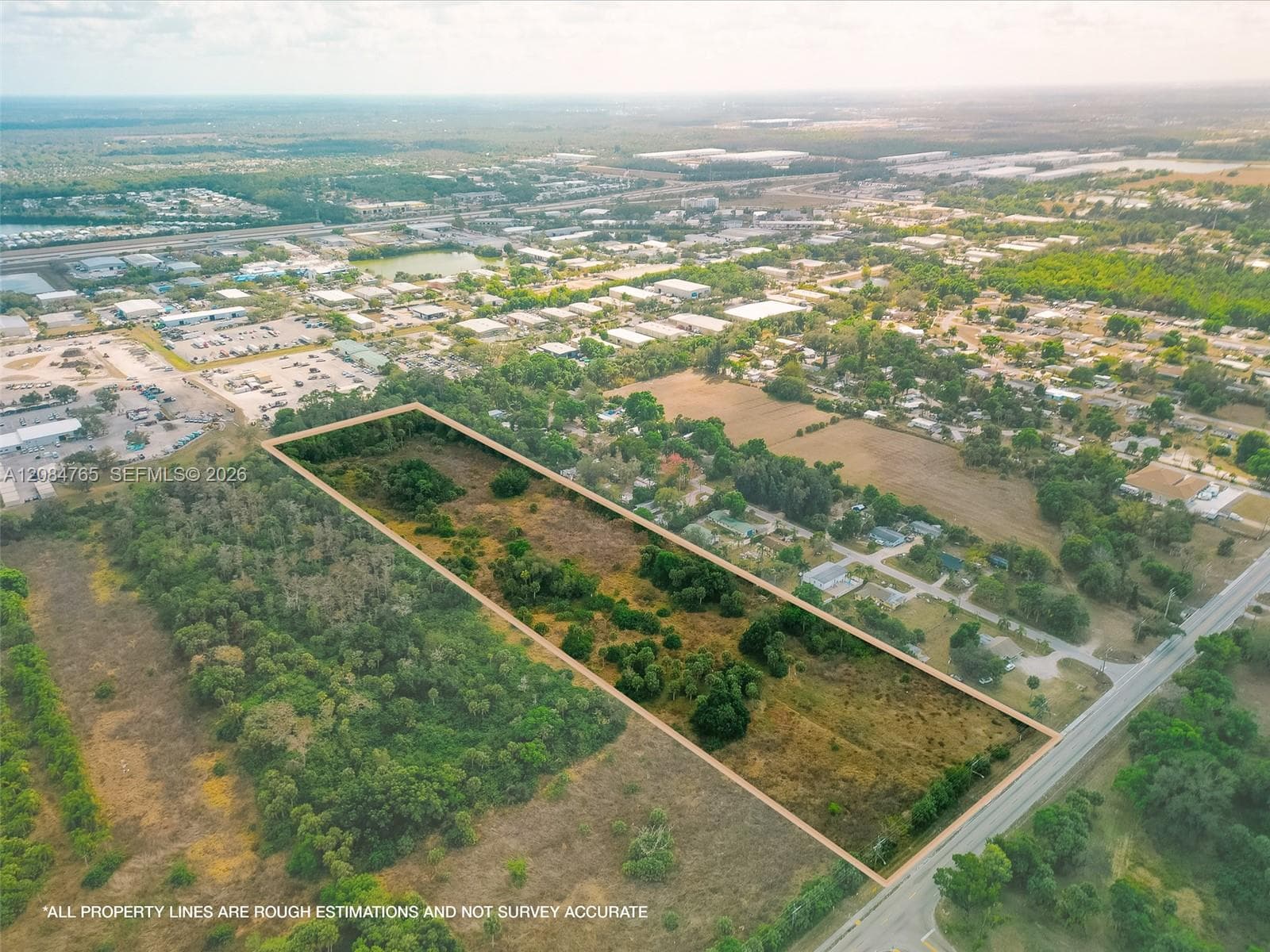 Aerial view showing the land parcel adjacent to paved roadways, providing convenient access and visibility for prospective buyers.