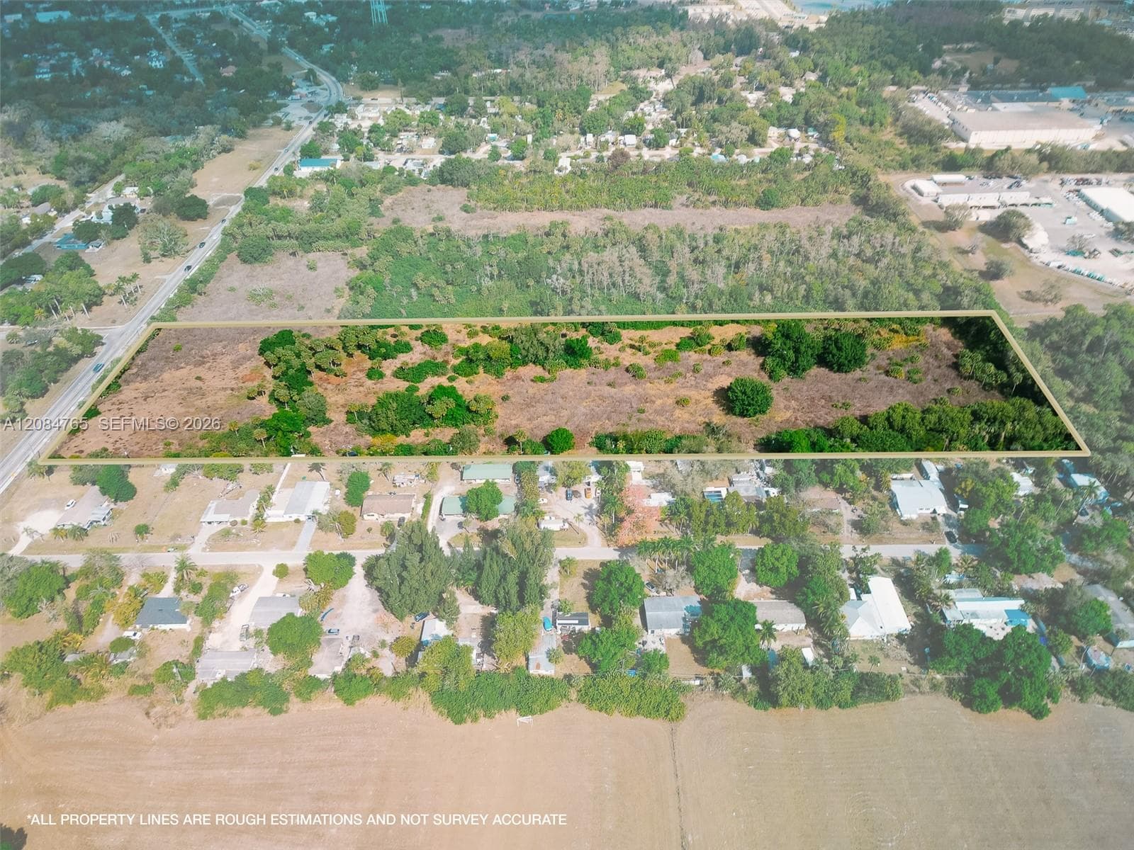 Bird's-eye view of the vacant land parcel bordering a growing residential community, offering excellent potential for new construction or land investment.