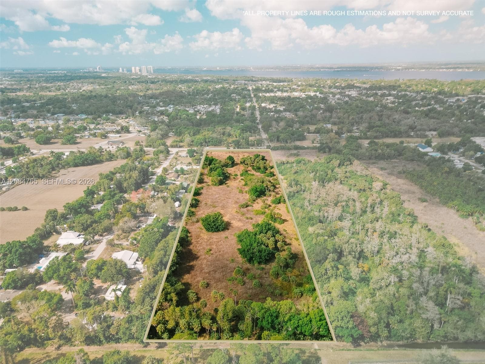 Drone photography reveals a dense tree canopy within the parcel boundaries of this vacant land, offering privacy and natural beauty for future development.
